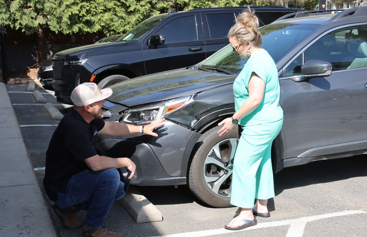 fender that needs to be repaired, woman talking to Richies Body Shop employee